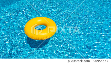 Yellow ring floating in blue swimming pool. Inflatable ring, rest concept Yellow ring floating in blue swimming pool. Inflatable ring, rest concept 90954547