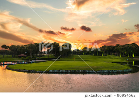Sunset at the golf course. Scenic panoramic view of golf fairway 90954562