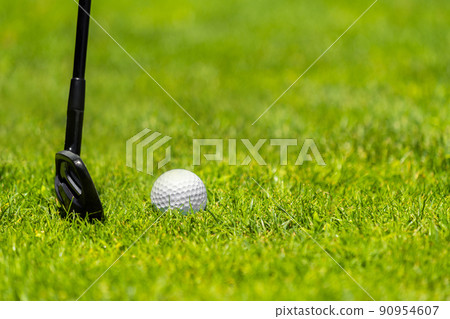 Golf ball and golf club on green grass on golf course 90954607