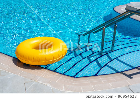 Yellow ring floating in refreshing blue swimming pool 90954628