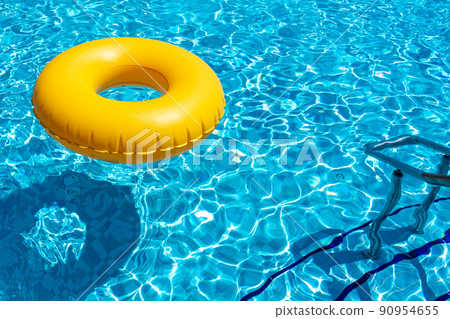 Yellow ring floating in refreshing blue swimming pool 90954655
