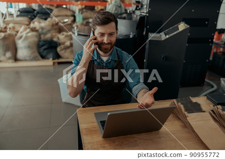 Business owner talking with client while sit on own small coffee factory Business owner talking with client while sit on own small coffee factory 90955772