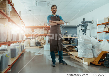 Smiling business owner standing on the background of coffee roasting machine 90955778