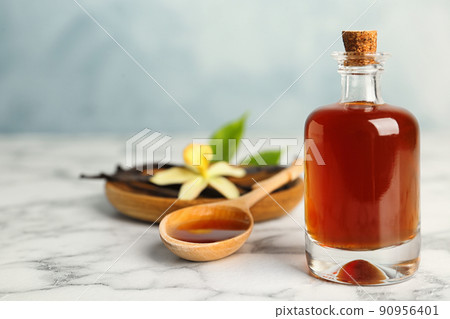 Aromatic homemade vanilla extract on marble table. Space for text 90956401