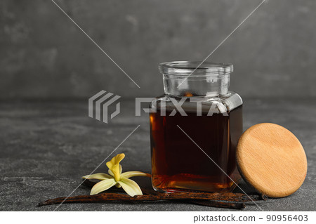 Aromatic homemade vanilla extract on grey table 90956403