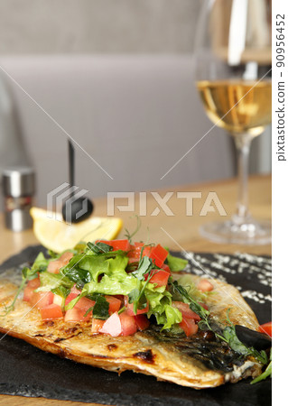 Delicious grilled fish with vegetables served on wooden table. Space for text 90956452
