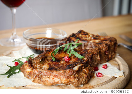 Delicious grilled ribs on wooden board, closeup 90956552