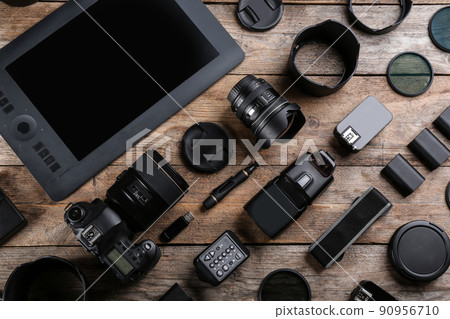 Flat lay composition with equipment for professional photographer on wooden table Flat lay composition with equipment for professional photographer on wooden table 90956710