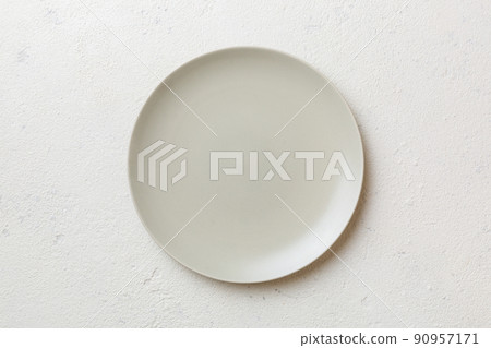 Top view of empty light plate on cement background. Empty space for your design Top view of empty light plate on cement background. Empty space for your design 90957171