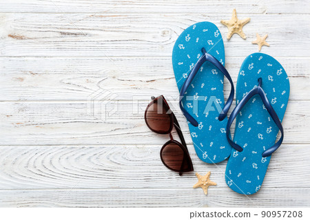 Summer travel concept. Flip flops, sunglasses and starfish on white. Top view on colored background 90957208