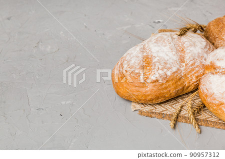 Homemade natural breads. Different kinds of fresh bread as background, perspective view with copy space Homemade natural breads. Different kinds of fresh bread as background, perspective view with copy space 90957312