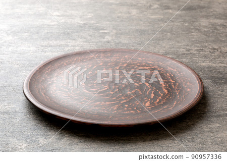 Perspective view of empty plate on cement background. Empty space for your design Perspective view of empty plate on cement background. Empty space for your design 90957336