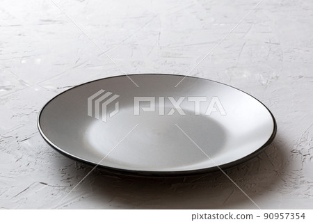 Perspective view of empty colorful plate on cement background. Empty space for your design Perspective view of empty colorful plate on cement background. Empty space for your design 90957354