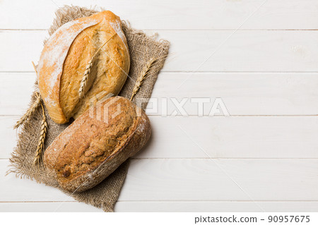 Assortment of freshly baked bread with napkin on rustic table top view. Healthy unleavened bread. French bread 90957675