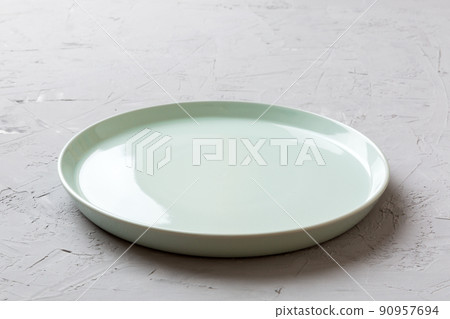 Perspective view of empty blue plate on cement background. Empty space for your design Perspective view of empty blue plate on cement background. Empty space for your design 90957694