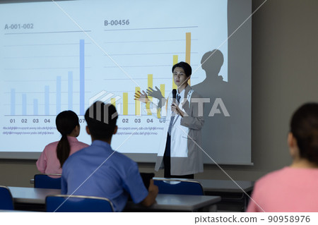 A man in a lab coat giving a presentation 90958976