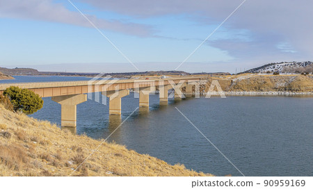 Pano A clear and peaceful lake with snow on the edge and bridge to the side Pano A clear and peaceful lake with snow on the edge and bridge to the side 90959169