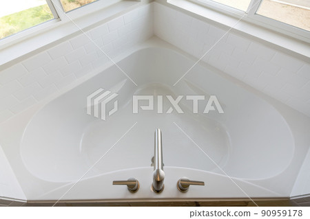 Corner bathtub top view with white tile surround wall 90959178
