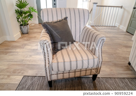 Living room interior with armchair against front door and indoor stairs 90959224