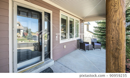 Pano Front porch of a house with engineered wood siding wall and log column post 90959235
