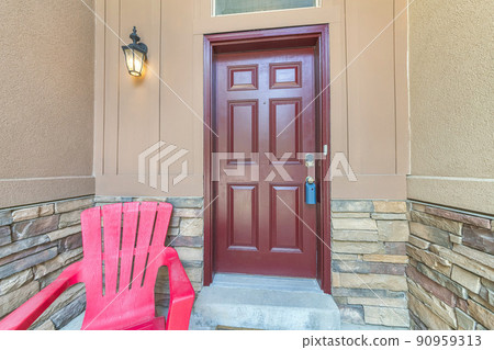 Burgundy door with blue lockbox and wall lamp on the left 90959313