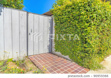 Wood fence gate with red stone tiles entrance at La Jolla in San Diego, California 90959366