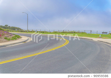 Curved road with double yellow lanes at Laguna Niguel in Southern California 90959386