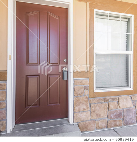 Square frame Front door exterior of a house with half stone and wooden wall 90959419