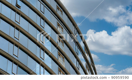 Panorama White puffy clouds Low angle view of a curved building with windows and tinted refl 90959590