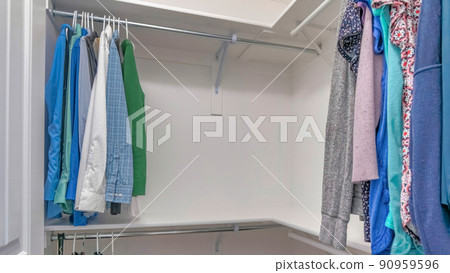 Panorama Walk in closet with an L-shaped wall mounted shelves with metal rods 90959596