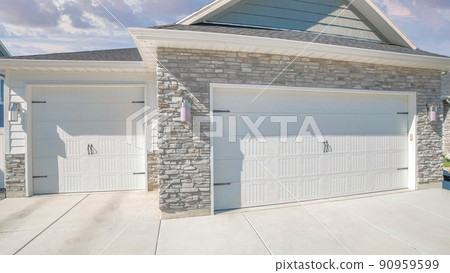Panorama Puffy clouds at sunset Three-car side hinged garage doors with stone veneer wall siding Panorama Puffy clouds at sunset Three-car side hinged garage doors with stone veneer wall siding 90959599