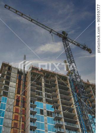 Vertical Puffy clouds at sunset Low angle view of an unfinished building with tower cranes at Sa Vertical Puffy clouds at sunset Low angle view of an unfinished building with tower cranes at Sa 90959777