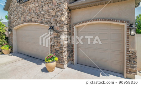 Panorama White puffy clouds Double arched sectional garage doors with potted plants outside Panorama White puffy clouds Double arched sectional garage doors with potted plants outside 90959810