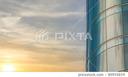 Panorama Puffy clouds at sunset Curved building exterior with glass curtain wall against the clo Panorama Puffy clouds at sunset Curved building exterior with glass curtain wall against the clo 90959834