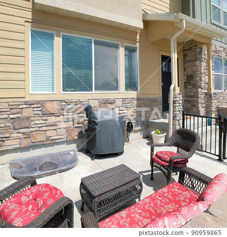 Square White puffy clouds Patio of a townhouse with woven set of couch and armchairs Square White puffy clouds Patio of a townhouse with woven set of couch and armchairs 90959865