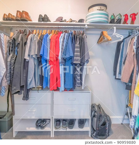 Square Interior of a windowless walk in closet with clothes and shoes Square Interior of a windowless walk in closet with clothes and shoes 90959880