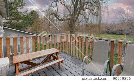 Panorama Puffy clouds at sunset Deck of a house with gray armchairs, outdoor dining table with b Panorama Puffy clouds at sunset Deck of a house with gray armchairs, outdoor dining table with b 90959896