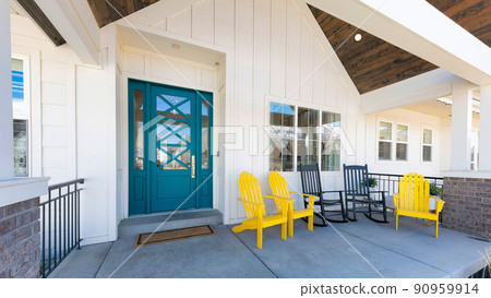 Panorama Porch of a house with blue green door and lounge chairs 90959914