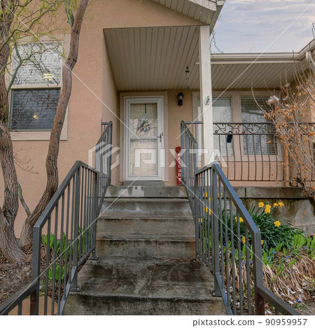 Square Puffy clouds at sunset Concrete stairs with metal railings leading to a front door Square Puffy clouds at sunset Concrete stairs with metal railings leading to a front door 90959957