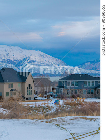 Vertical Whispy white clouds Snow covered field outside the residential area at Saratoga Springs in Utah 90960055