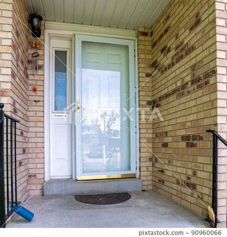 Square Front door of a house with bricks and metal railings 90960066