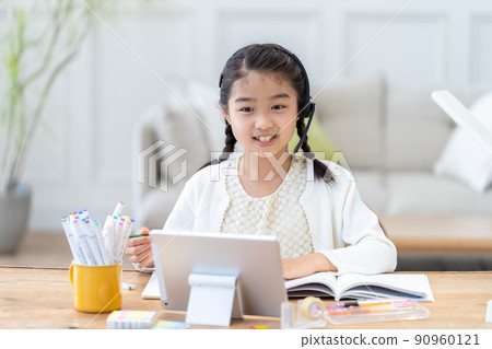 一邊看平板電腦一邊學習的小學女生 90960121