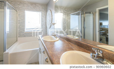 Pano Master bathroom with a warm lightning and stone tile walls 90960602