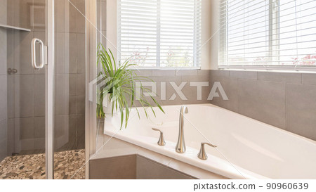 Pano Interior of a bathroom with windows, bathtub and shower stall with glass 90960639