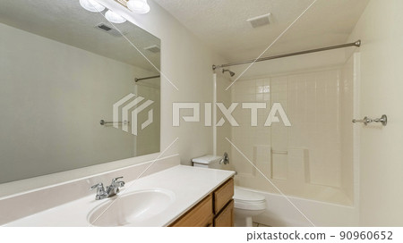 Pano Bathroom interior with long vanity sink and bathtub with shower 90960652
