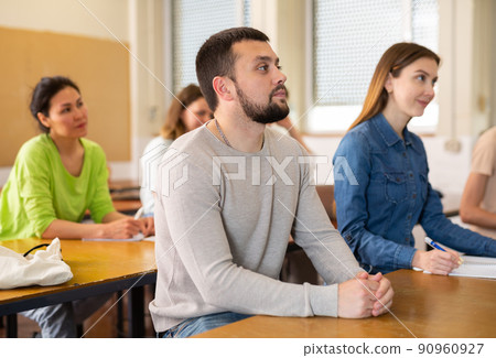 Portrait of a young student listening attentively to a teachers lecture Portrait of a young student listening attentively to a teachers lecture 90960927