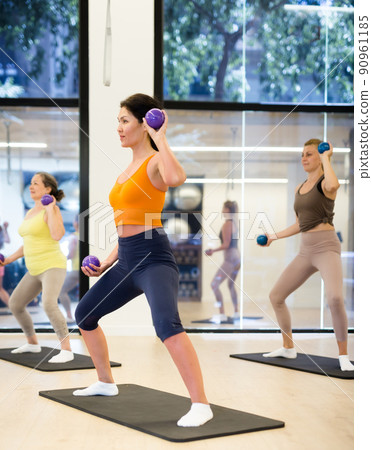 Aerobics pilates women with toning balls in row on fitness class Aerobics pilates women with toning balls in row on fitness class 90961185