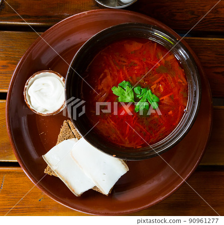 Traditional Ukrainian borsch with sour cream in bowl, bread with bacon Traditional Ukrainian borsch with sour cream in bowl, bread with bacon 90961277