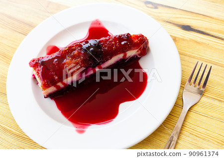 Slice of delicious classical cheesecake with fruity sauce served Slice of delicious classical cheesecake with fruity sauce served 90961374