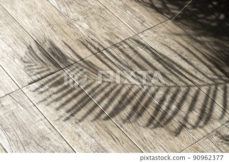 Shadow of coconut leaves on wood surface 90962377